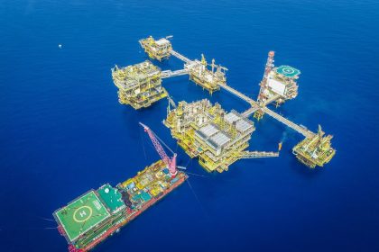 Vista aérea de um complexo de plataformas de exploração offshore em alto-mar.
