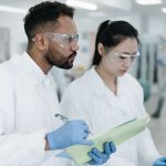 Dois pesquisadores colaboram em um laboratório moderno durante uma atividade científica.