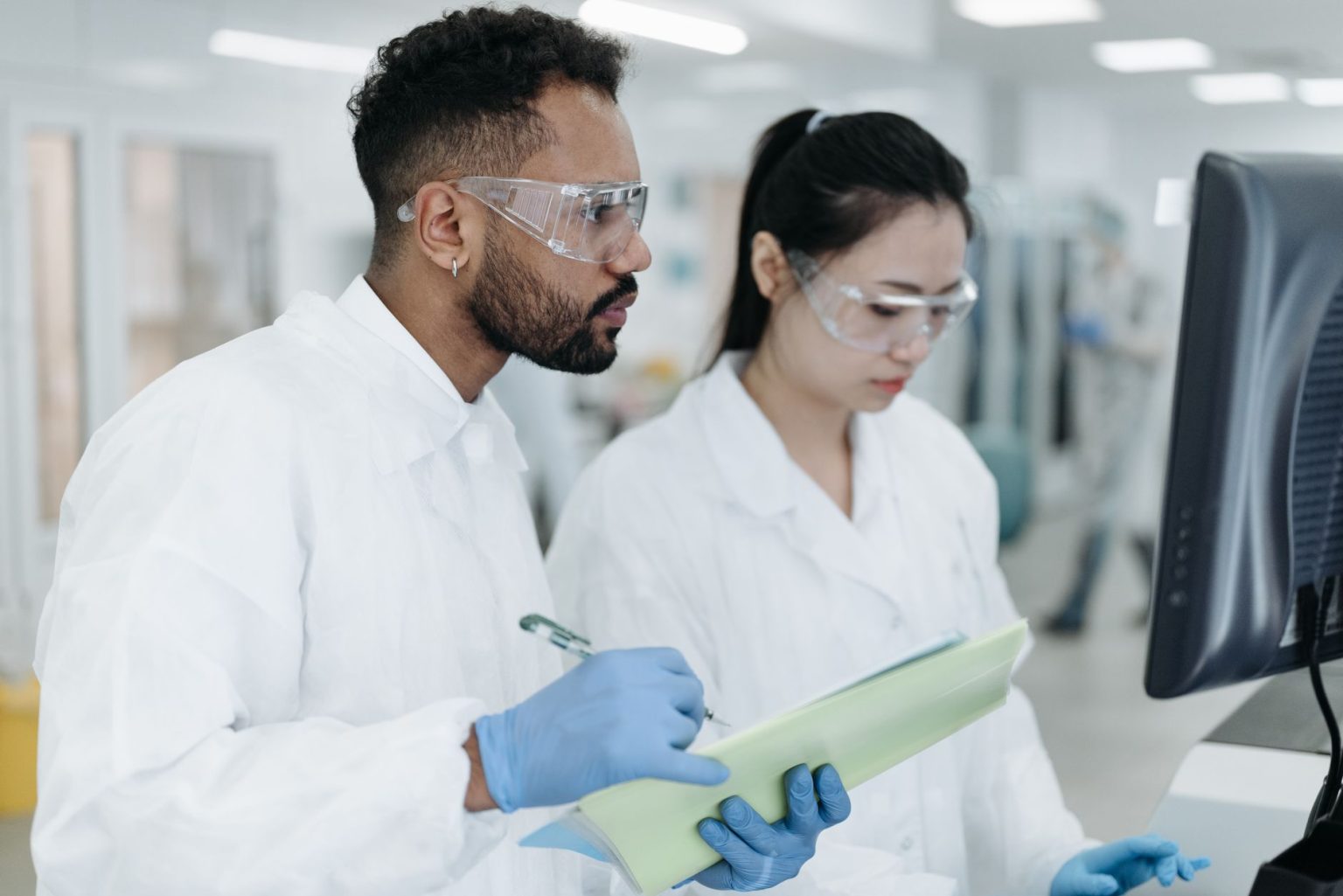 Dois pesquisadores colaboram em um laboratório moderno durante uma atividade científica.